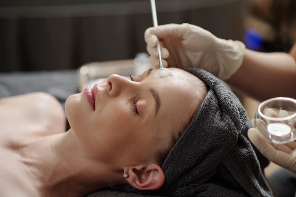 Woman lying down in clinic with face mask being applied